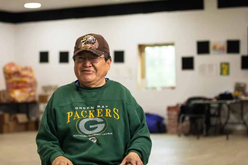 Smiling Alaska Native elder in a green sweatshirt